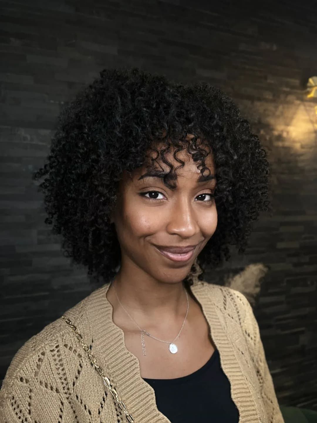 Coupe sur boucles naturelles avec frange bouclée, définition sans lissage