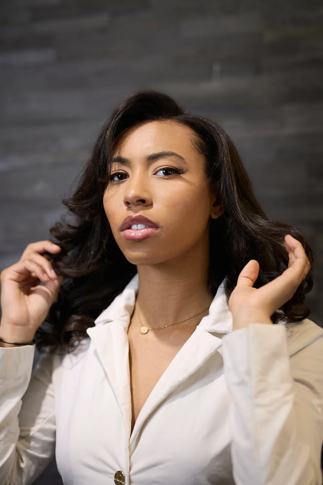 Brushing ondulé glamour, volume et brillance sur cheveux noirs